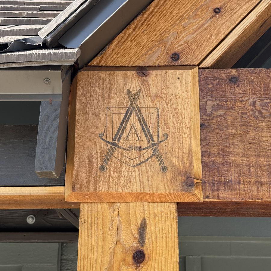 The Alcove crest laser-burned into the cedar beam over the front entry