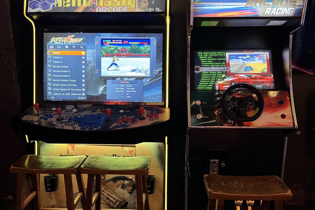 The multicade cabinet and the sit-down racing machine, screens lit