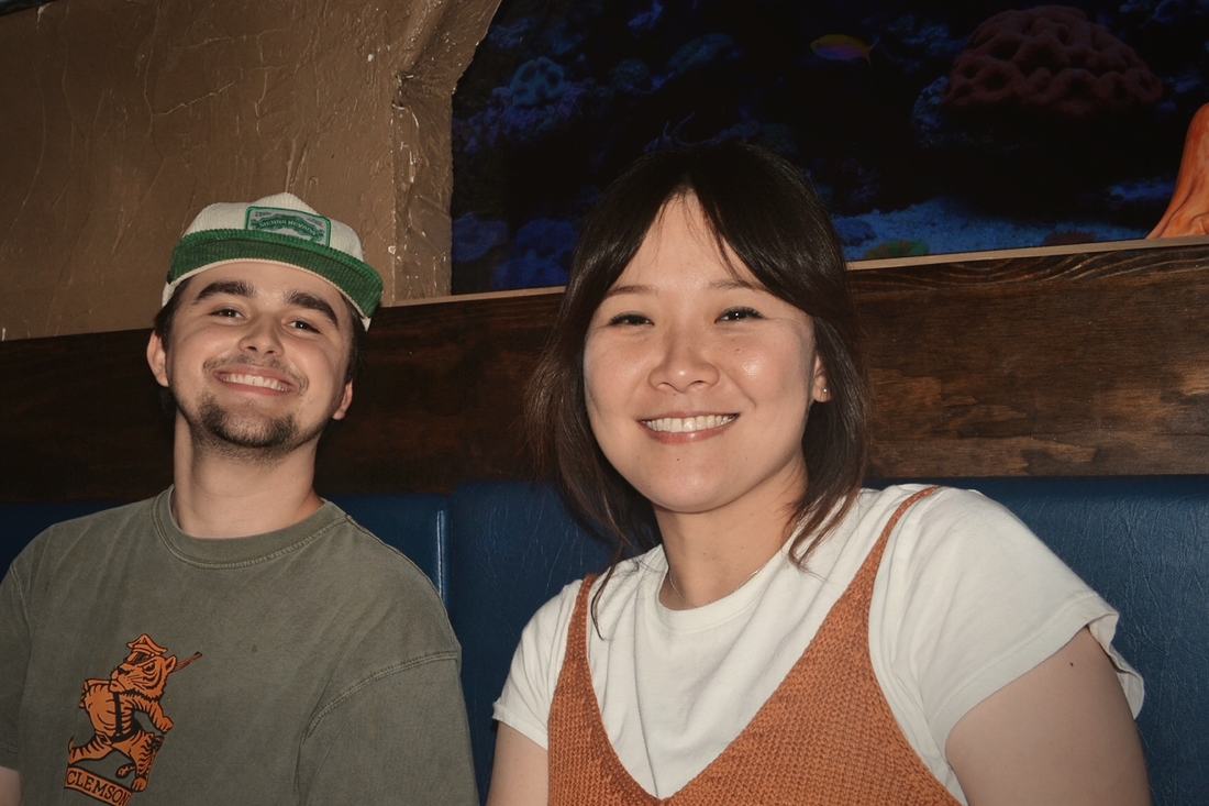 Two guests in a booth beside the tavern's saltwater aquarium.